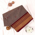 Chettinad cotton saree with zari buttas and zari border in Light brown and maroon folded top view