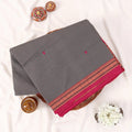Chettinad cotton saree with light grey plain body temple zari border and woven butta motifs folded top view.