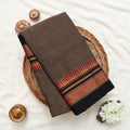 Narayanpet Cotton saree with deep brown body and gold zari woven border, folded top view