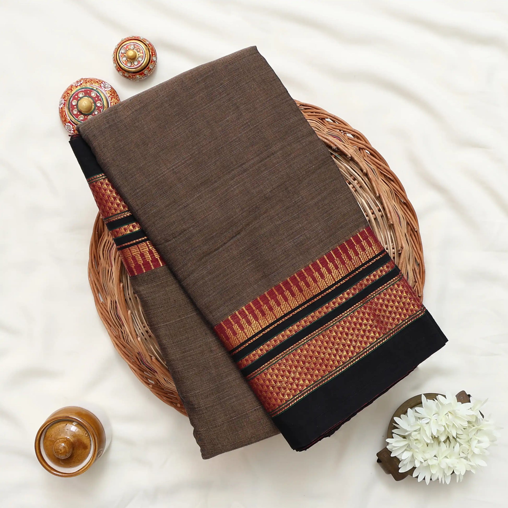 Narayanpet Cotton saree with deep brown body and gold zari woven border, folded top view