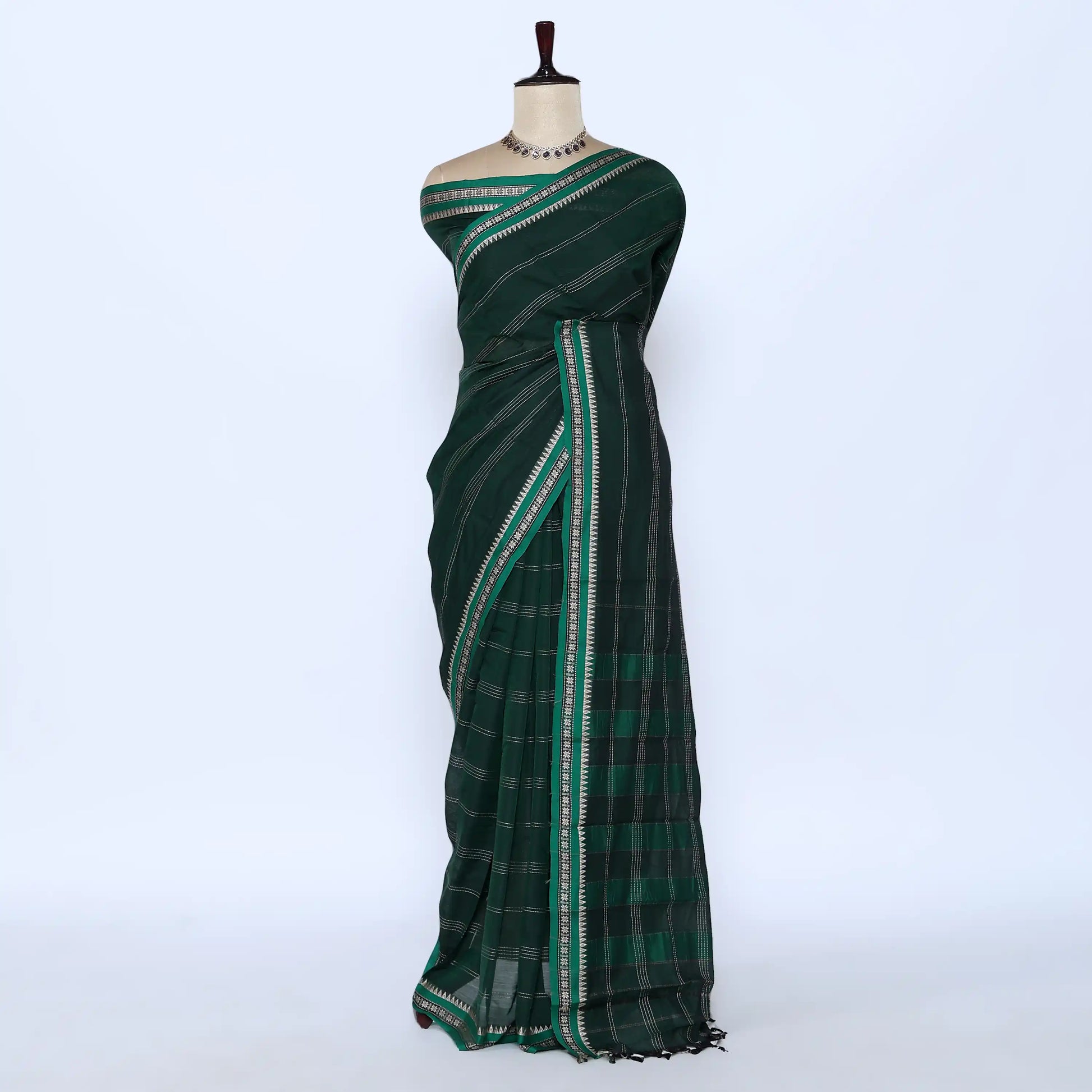 A dark green saree with a subtle plaid pattern and a contrasting border of white and light green stripes
