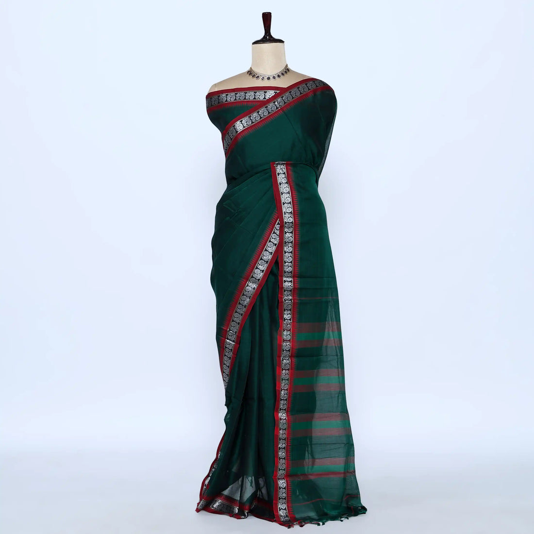 A dark green saree with red and silver patterned borders