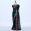 A dark green saree with red and silver patterned borders
