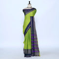 A green and navy blue saree with purple and gold patterned borders