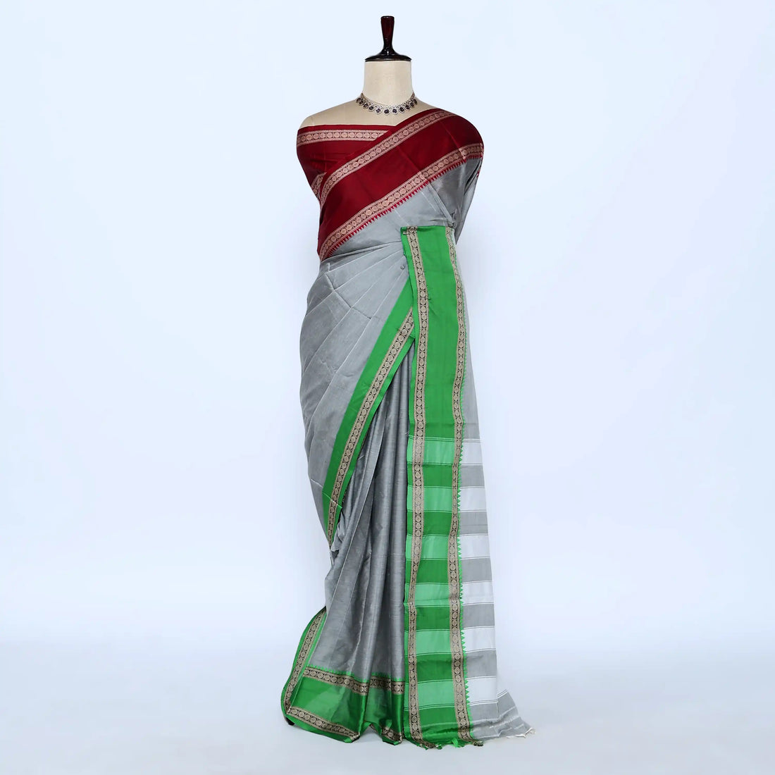 A gray and green saree with a deep red and green border