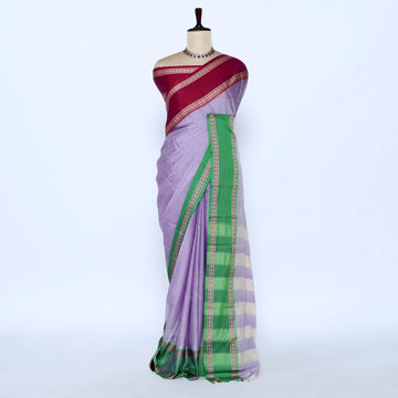 A lavender purple saree with a green and gold checkered border and a deep maroon red pallu
