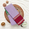 A lavender purple saree with a green and gold checkered border and a deep maroon red pallu