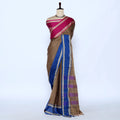 A brown saree with a magenta pink and blue border