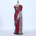 A deep red saree with a metallic silver and gold striped border