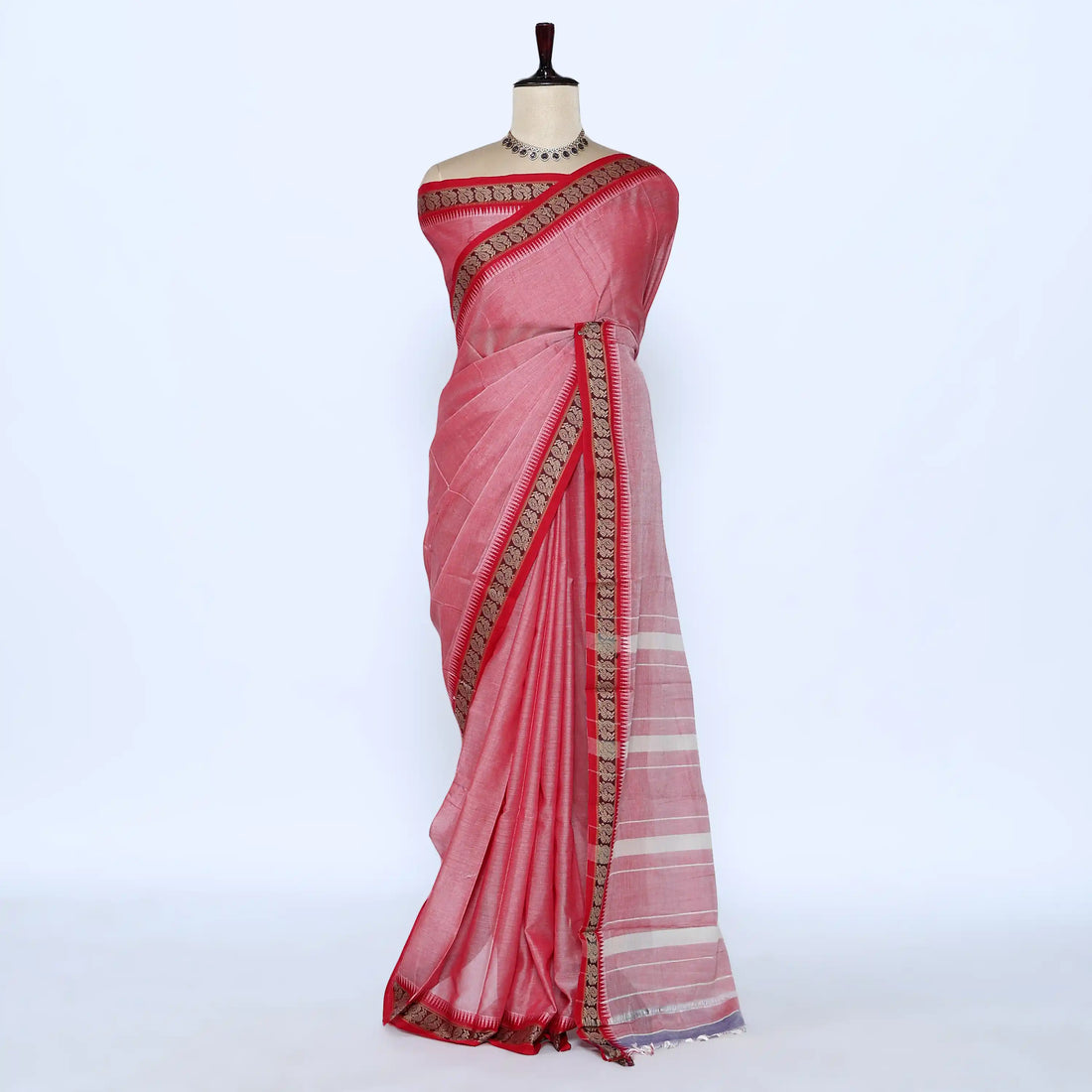 A pink cotton saree with a striped pallu and a gold patterned border