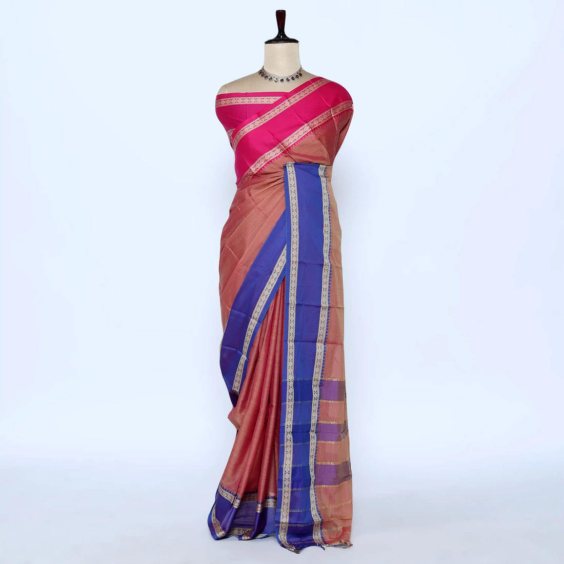 A pink and rust-colored saree with a royal blue border and gold zari stripes