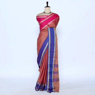 A pink and rust-colored saree with a royal blue border and gold zari stripes