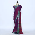 A deep purple saree with green and silver patterned borders