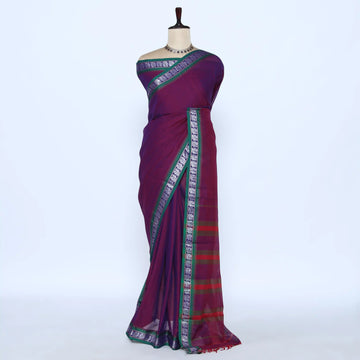 A deep purple saree with green and silver patterned borders