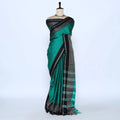 A green and black saree features a solid green body with black borders and a patterned pallu.