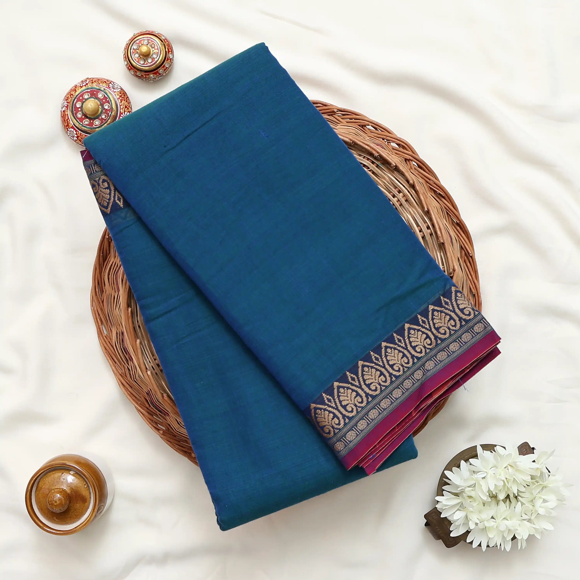 Narayanpet Cotton Saree with Floral Zari Woven Border Teal Folded Top View on Wicker Basket