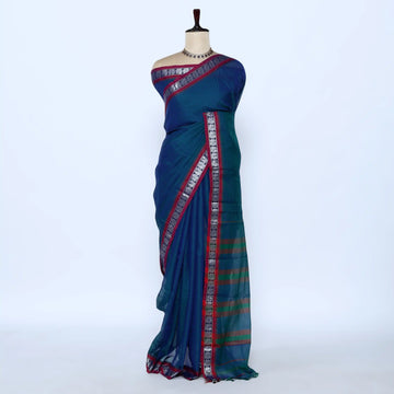 A blue and green saree with red and silver borders