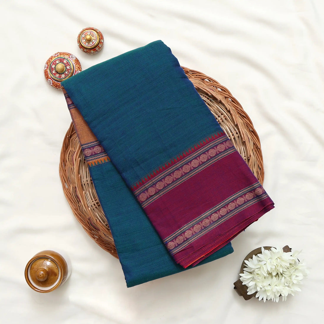 A teal blue and magenta saree with a red and yellow checkered border