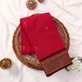 Kanchi Cotton Saree With Zari Border In Bright Pink Neatly Folded On Wicker Basket Top View Product Display
