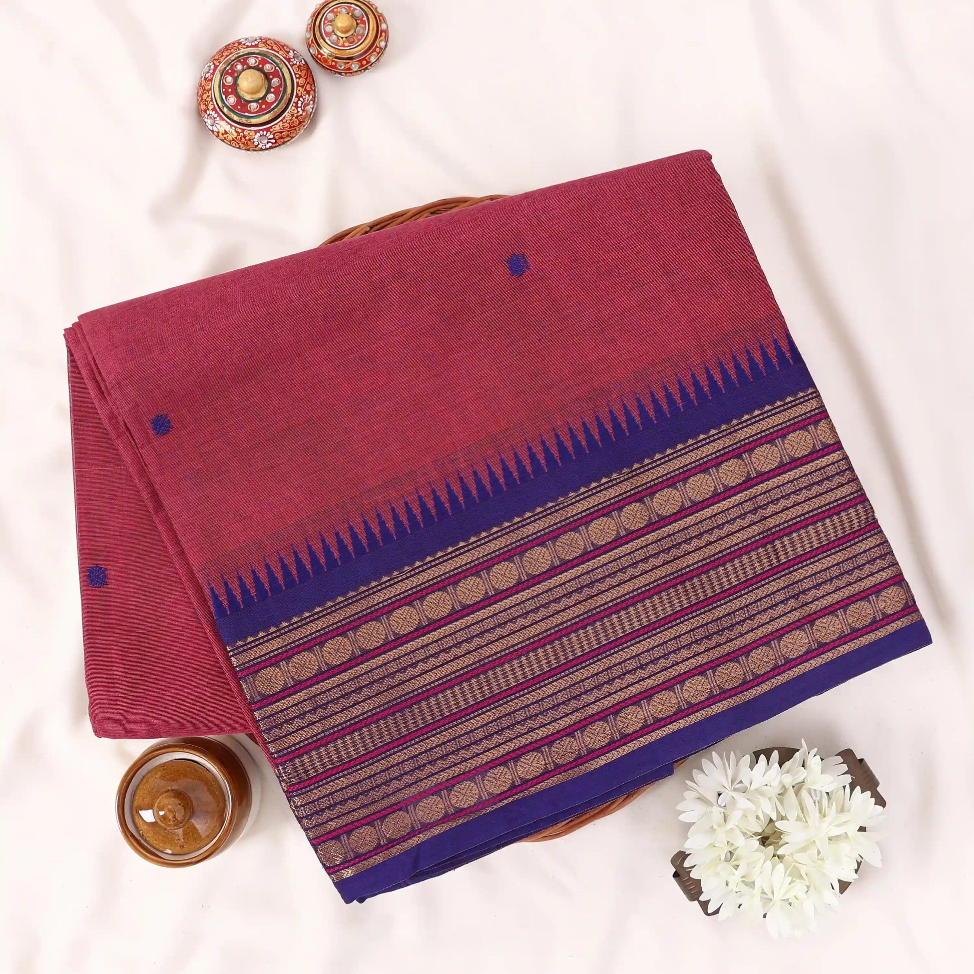 Chettinad cotton saree with zari buttas and zari border in pink and blue folded top view