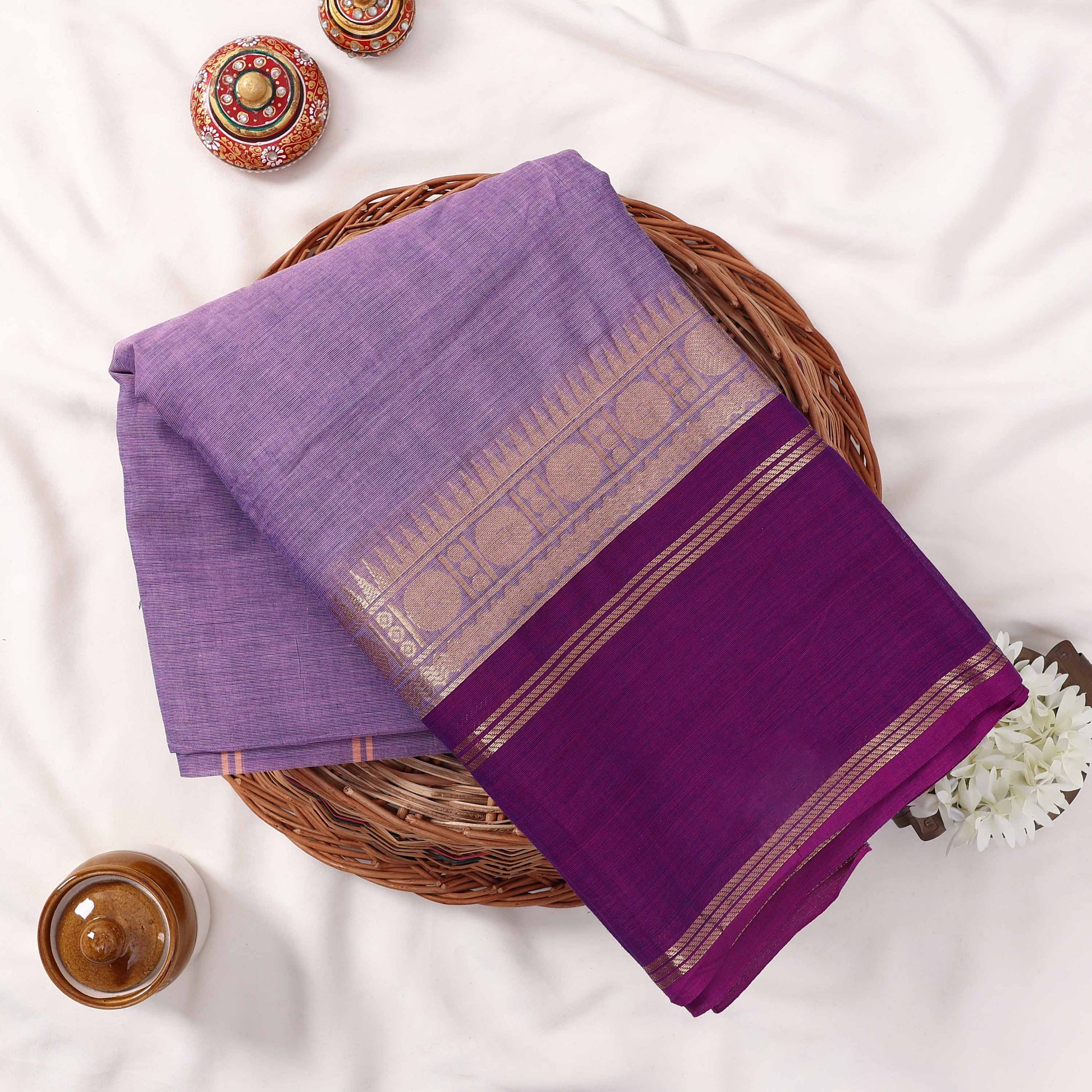 Kanchi Cotton Saree With Purple Body And Vibrant Purple Zari Border Neatly Folded In A Top View Flat Lay
