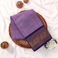 Kanchi Cotton Saree With Purple Body And Navy Blue Zari Border Top View Flat Lay In Basket With Flowers
