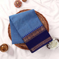 Kanchi Cotton Saree With Textured Sky Blue Body And Royal Blue Zari Border Folded On Wicker Tray Top View
