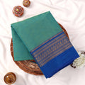 Kanchi Cotton Saree With Teal Green Body And Royal Blue Zari Border Top View Flat Lay With Decorative Accents 