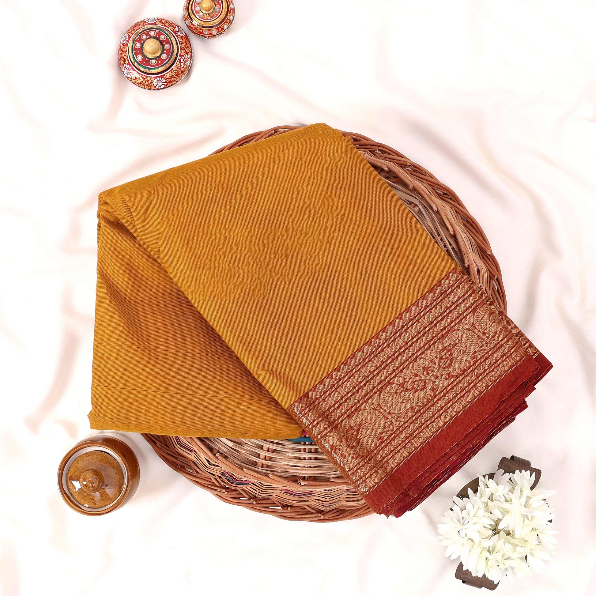 Kanchi Cotton Saree With Zari Woven Maroon Border In Yellow Neatly Folded In Flat Lay Display View
