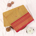 Chettinad cotton saree with zari buttas and zari border in mustard yellow and pink folded top view