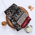 Black Semi Chanderi saree with peacock floral print and contrast woven border folded flat lay display.