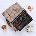 Cream Semi Chanderi saree with bandhani dot print and deer & floral woven border folded flat lay display.