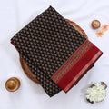 Semi Chanderi saree with delicate printed motifs in red and black folded display top view with decorative border.