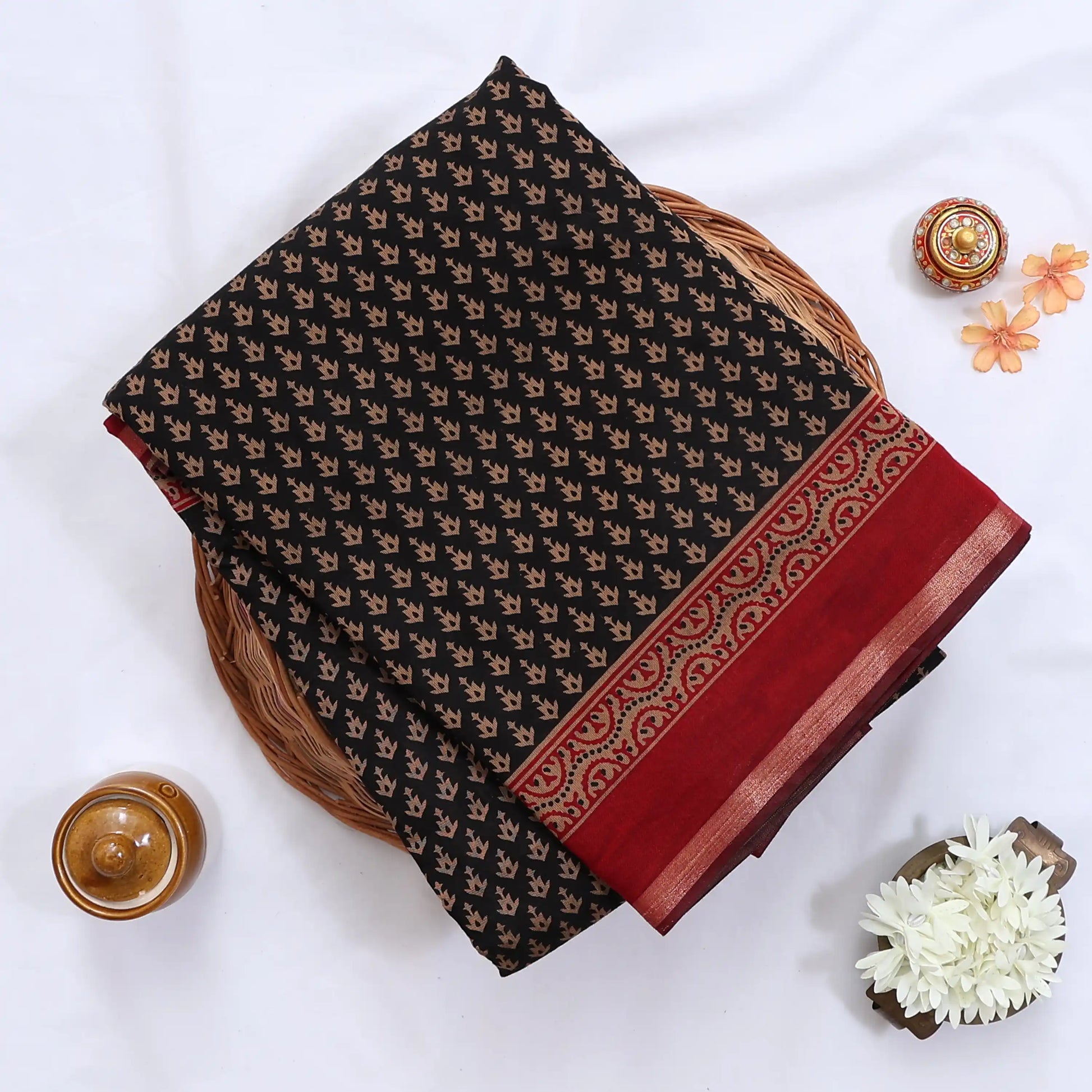 Semi Chanderi saree with delicate printed motifs in red and black folded display top view with decorative border.