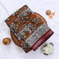 Brown Semi Chanderi saree with floral peacock print and contrast woven border folded flat lay display.