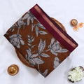 Brown semi Chanderi saree featuring white floral print and maroon border folded top view