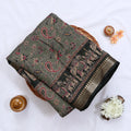 Semi Chanderi saree with floral paisley print and traditional elephant border in green folded top view.