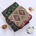 Semi Chanderi saree with floral and bird print in dark green and red folded close up product view.