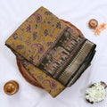 Semi Chanderi saree with floral paisley print and traditional elephant border in olive green folded top view.