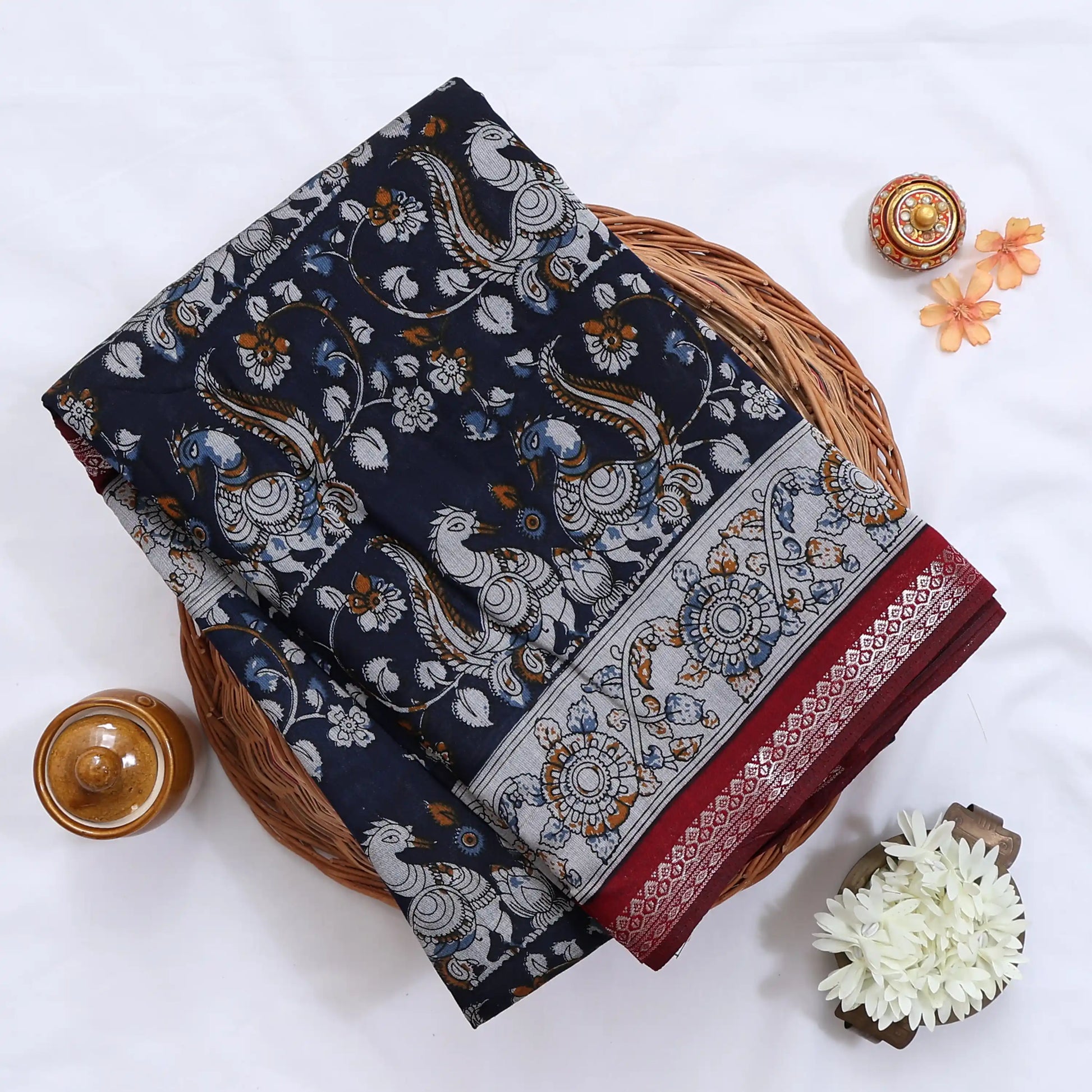 Navy Blue Semi Chanderi saree with floral peacock print and contrast woven border folded flat lay display.