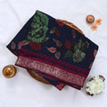 Navy Blue Semi Chanderi saree with floral leaf print and contrast zari woven border folded flat lay display.