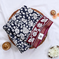 Semi Chanderi saree with white floral print navy blue body and maroon border folded top view