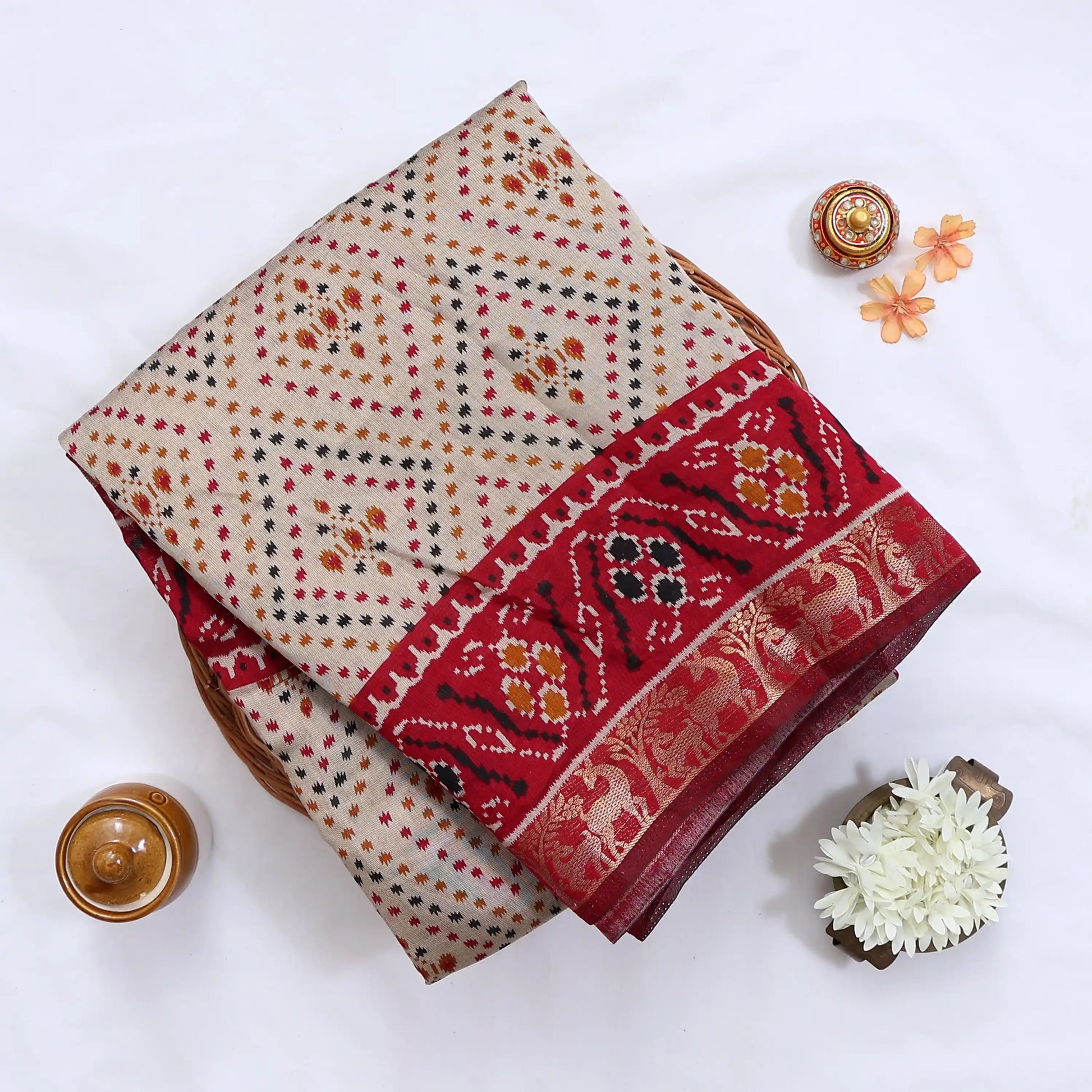 Cream Semi Chanderi saree with bandhani dot print and deer & floral woven border folded flat lay display.