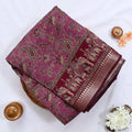 Semi Chanderi saree with floral paisley print and traditional elephant border in purple folded top view.