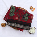 Red Semi Chanderi saree with floral leaf print and contrast zari woven border folded flat lay display.