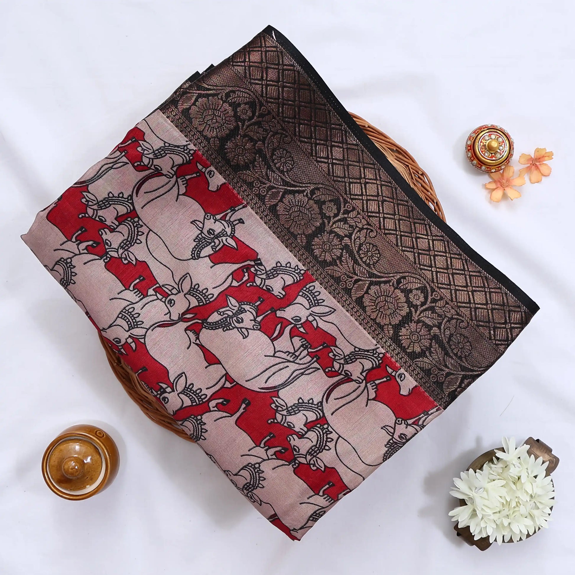 Semi Chanderi saree with cow motif print beige and red body with black zari border folded top view
