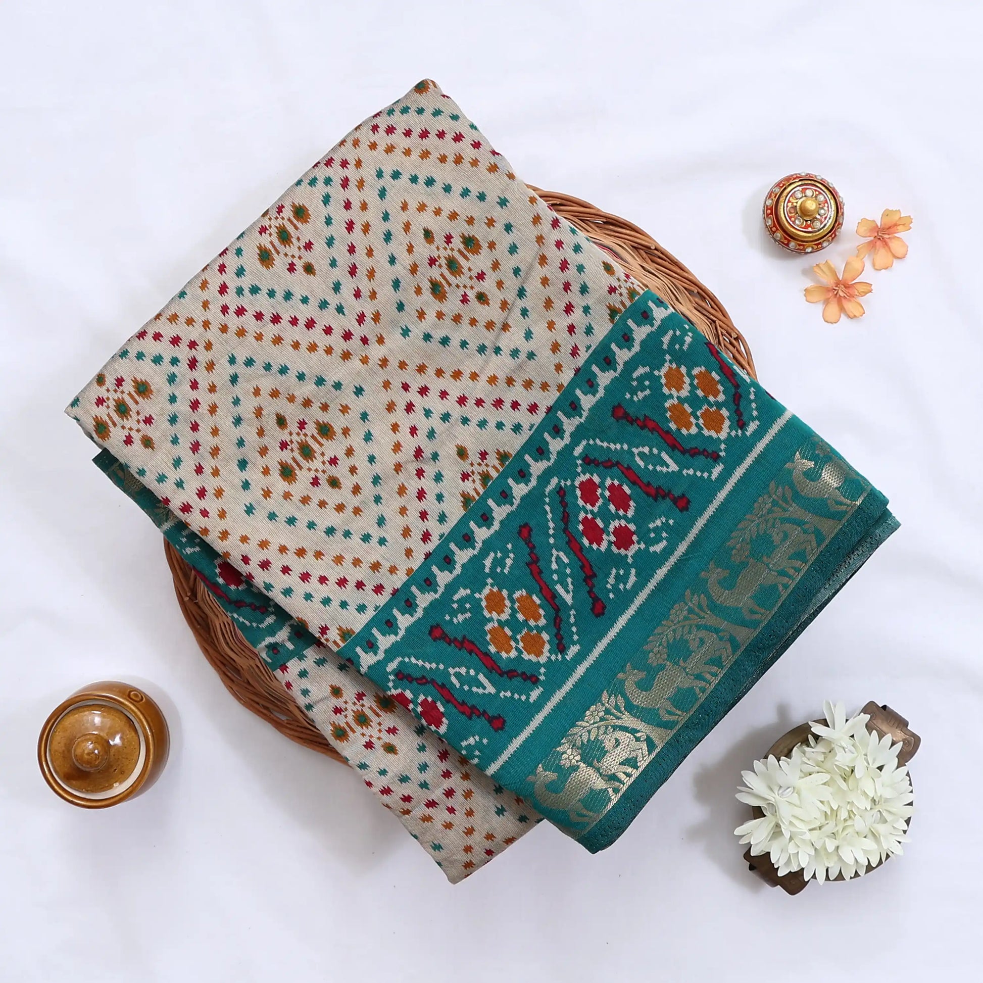 Cream Semi Chanderi saree with bandhani dot print and deer & floral woven border folded flat lay display.