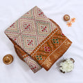 Cream Semi Chanderi saree with bandhani dot print and deer & floral woven border folded flat lay display.