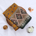 Semi Chanderi saree with floral and bird print in dark green and yellow folded close up product view.