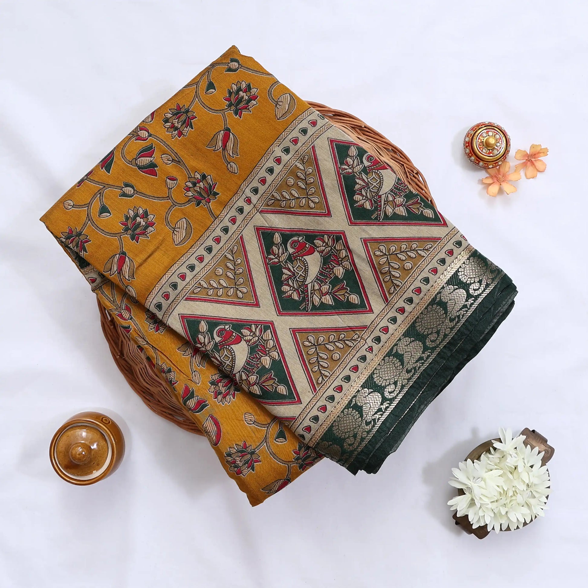 Semi Chanderi saree with floral and bird print in dark green and yellow folded close up product view.